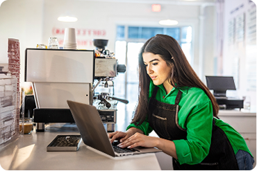 Woman talking on phone while holding tablet in office