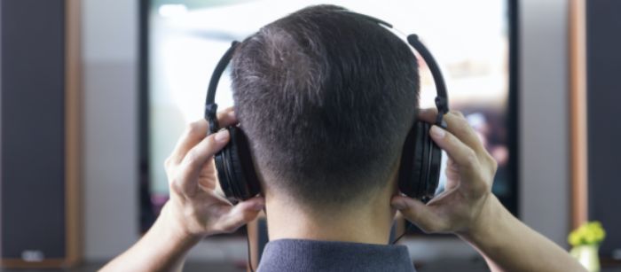 Man wearing headphones using the Spectrum Access App.