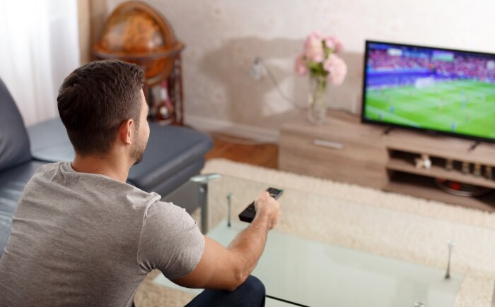 Military man watching a soccer game on Spectrum TV.