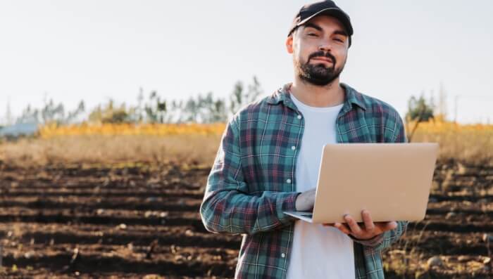 A young man using his laptop on a local farm