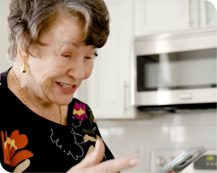 una mujer mayor usando un teléfono móvil respaldado por Spectrum