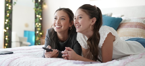 Friends on bed watching Spectrum TV