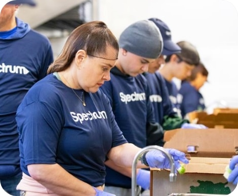 Voluntarios de Spectrum ayudando a preparar comidas y ordenar donaciones