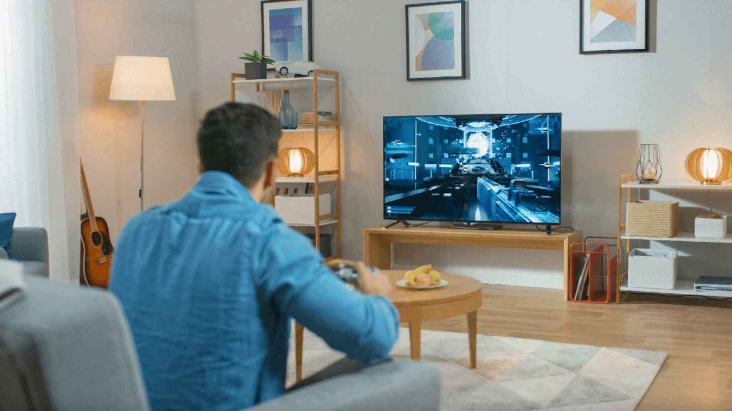 Hombre jugando a videojuegos en una TV