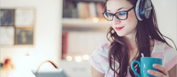 Female student wearing headphones while online with Spectrum Internet. 