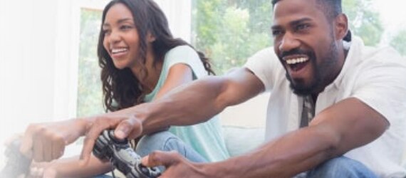 Man and woman having fun gaming with Spectrum Internet.