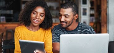 Couple looking at tablet and computer. 