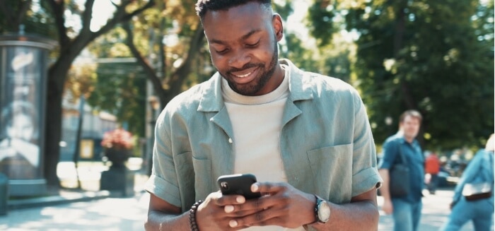 A young man enjoying his phone with a Spectrum Mobile data plan.