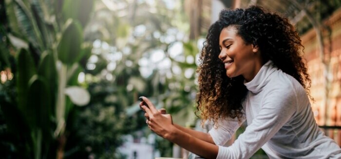 A woman exploring trade-in details on her mobile phone with Spectrum Mobile.