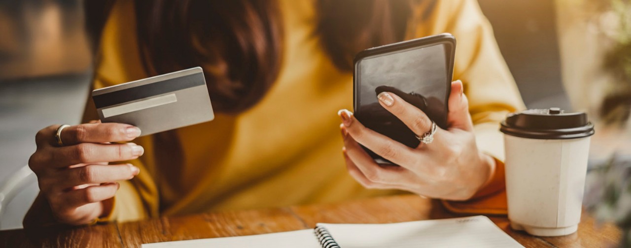 Woman using her smart phone and credit card for shopping online