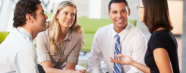 Group of business people sitting in a circle having a friendly conversation.