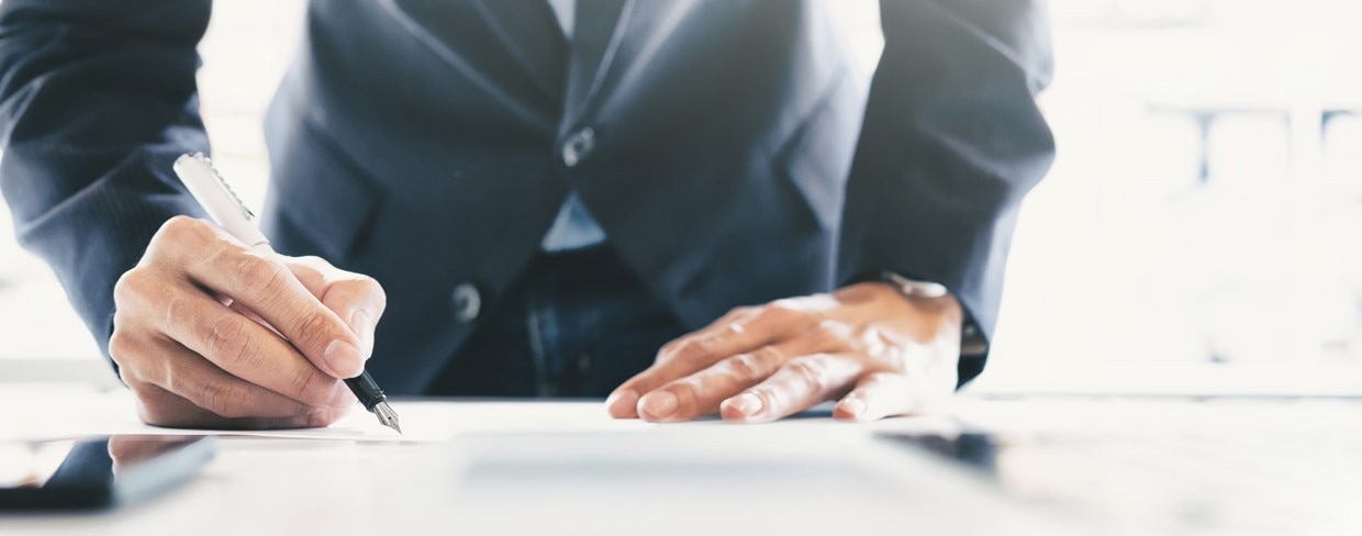Business person signs a document using a pen