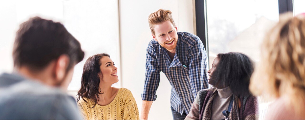 Businessman smiling at colleagues. 