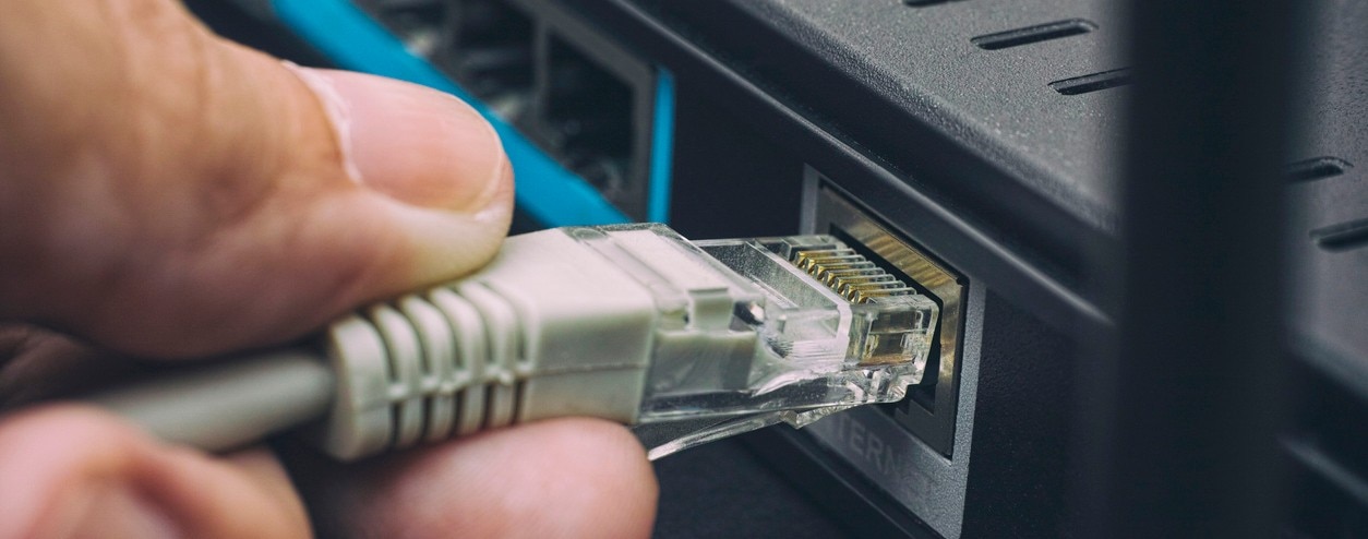 Person plugging in cable to wireless router. Close up.