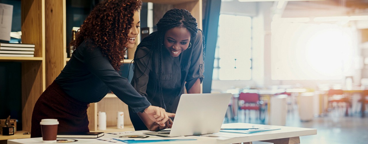 Shot of two business women discussing something on a laptop at the office