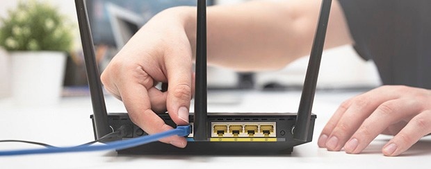 Hand connecting internet cable to router