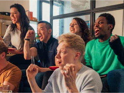 Friends watching a tv and cheering