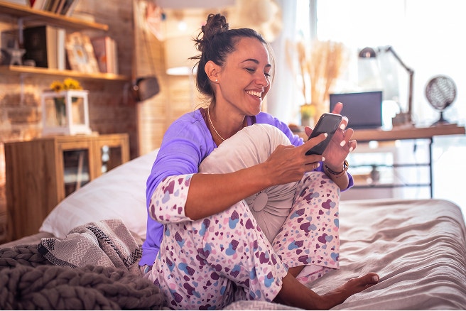 woman in bed using mobile device