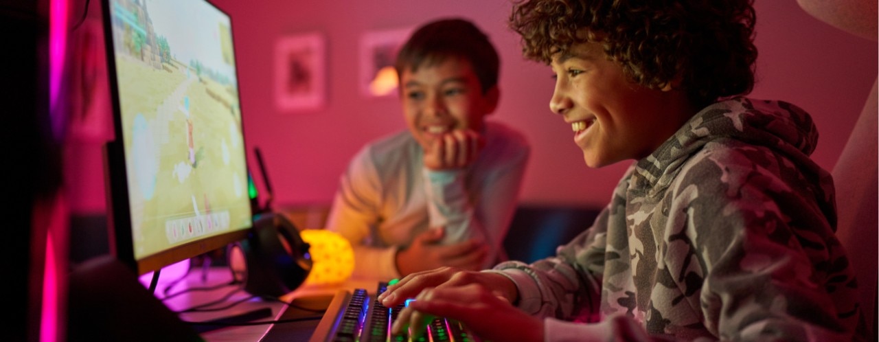 Dos niños jugando en una computadora de escritorio