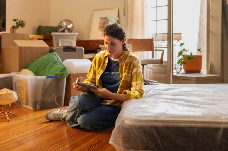 woman sitting on floor looking at tablet