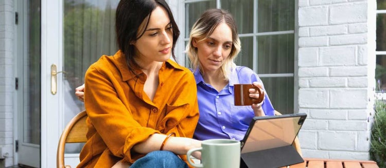 Two women using a tablet powered by Spectrum WiFi