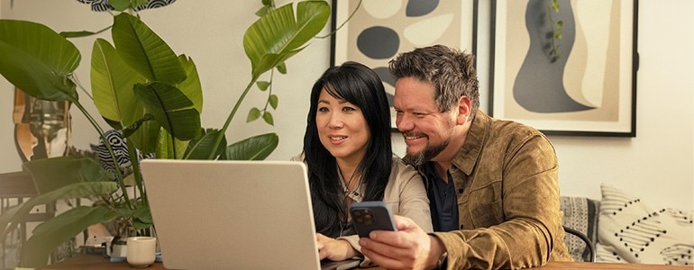 Woman on Laptop and Man on Cell Phone