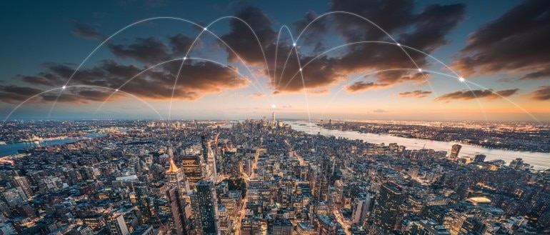 A city skyline with digital connectivity lines overlaying the scene