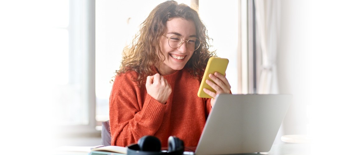 Excited woman looking at her cell phone and switching to Spectrum Mobile.