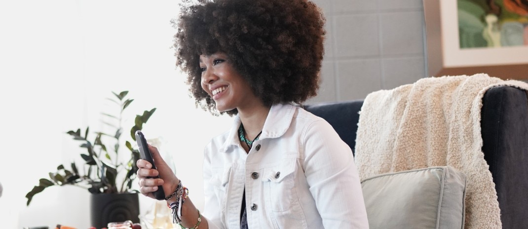 A woman using a tablet while smiling. 