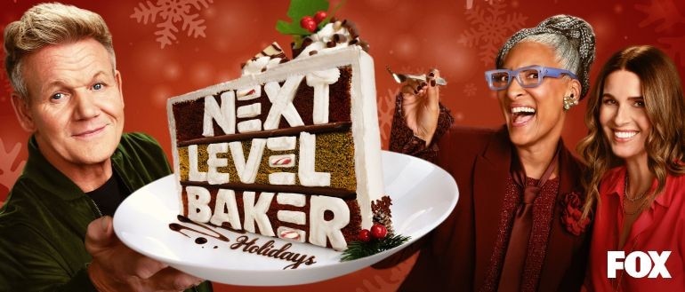 A hand pressing a button on a TV remote in front of a TV.