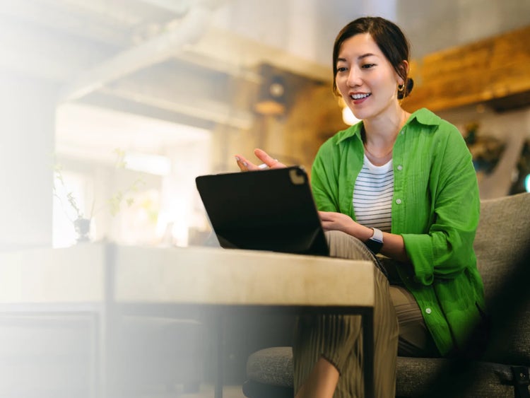 Woman video-calling on a tablet at home