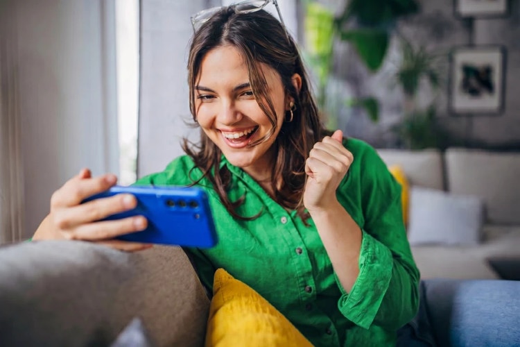 Woman in green using a Mobile device indoors